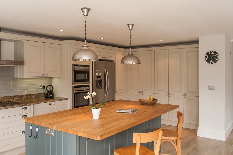 Inspiration for a large contemporary u-shaped open plan kitchen in Hertfordshire with a built-in sink, shaker cabinets, white cabinets, granite worktops, grey splashback, ceramic splashback, stainless steel appliances, marble flooring, an island and beige floors.