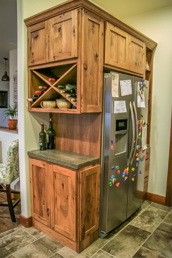 他の地域にあるお手頃価格の中くらいなラスティックスタイルのおしゃれなキッチン (中間色木目調キャビネット、コンクリートカウンター、シルバーの調理設備) の写真