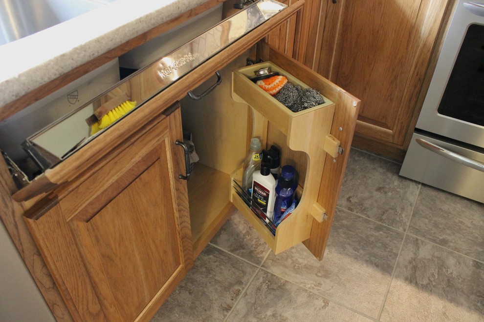 Bild på ett avskilt, mellanstort lantligt u-kök, med en undermonterad diskho, luckor med upphöjd panel, skåp i mellenmörkt trä, bänkskiva i kvarts, beige stänkskydd, stänkskydd i stenkakel, rostfria vitvaror och vinylgolv