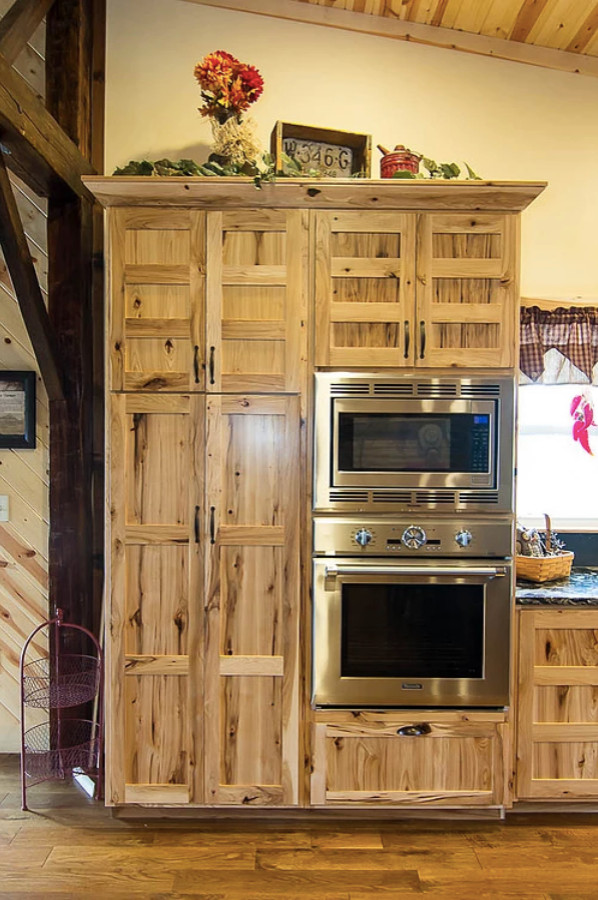 他の地域にある巨大なトラディショナルスタイルのおしゃれなキッチン (エプロンフロントシンク、落し込みパネル扉のキャビネット、淡色木目調キャビネット、マルチカラーのキッチンパネル、スレートのキッチンパネル、シルバーの調理設備、無垢フローリング、茶色い床、グレーのキッチンカウンター) の写真