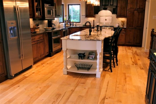 Mittelgroße Klassische Wohnküche in L-Form mit profilierten Schrankfronten, dunklen Holzschränken, Küchengeräten aus Edelstahl, hellem Holzboden und Kücheninsel in St. Louis