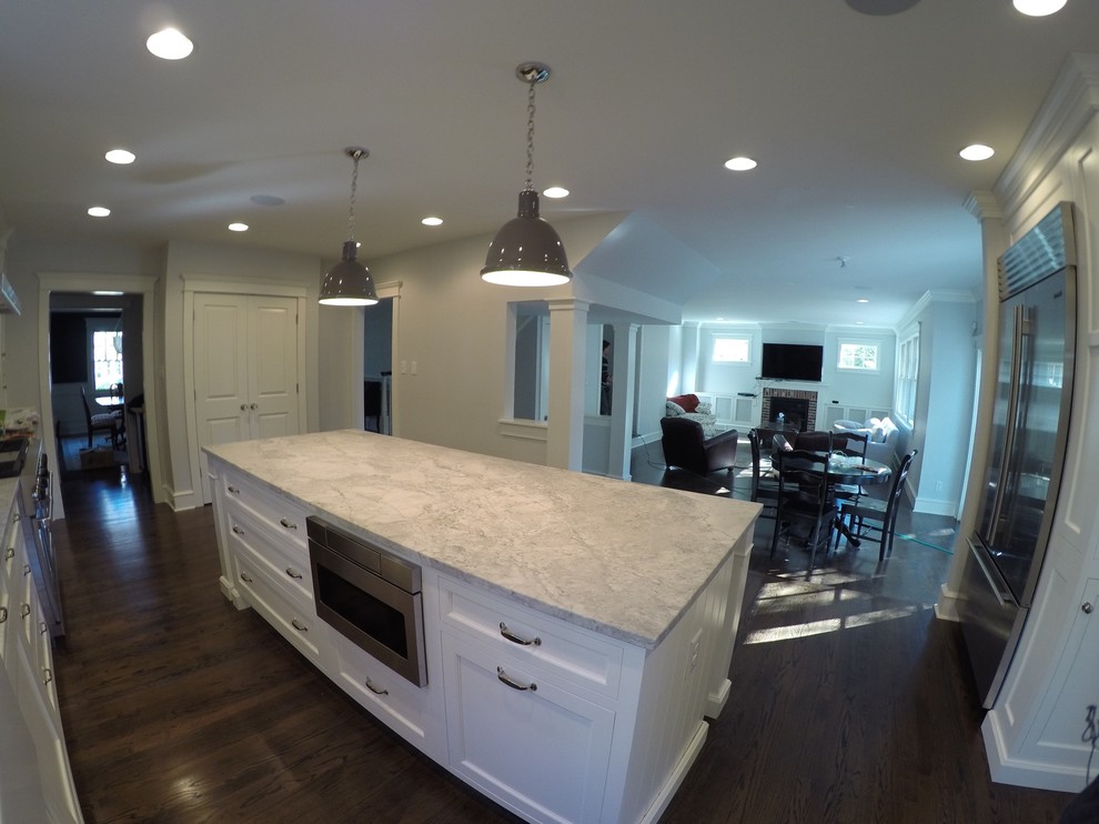 Example of a large transitional u-shaped dark wood floor and brown floor open concept kitchen design in Philadelphia with a farmhouse sink, shaker cabinets, white cabinets, marble countertops, gray backsplash, marble backsplash, stainless steel appliances and an island