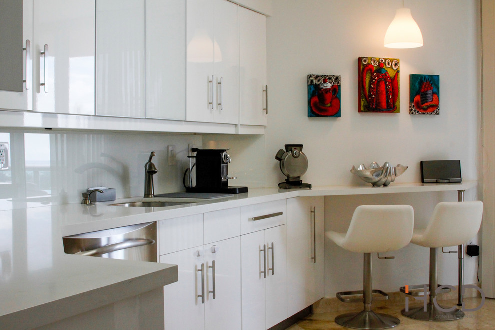 Small modern l-shaped enclosed kitchen in Miami with a submerged sink, flat-panel cabinets, white cabinets, quartz worktops, white splashback, stainless steel appliances, marble flooring and no island.