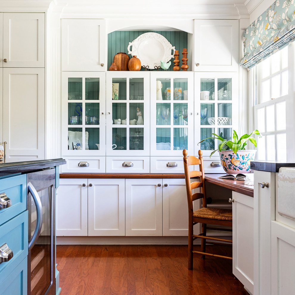 Inredning av ett klassiskt mellanstort kök, med en rustik diskho, vitt stänkskydd, stänkskydd i marmor, integrerade vitvaror, mellanmörkt trägolv och en köksö