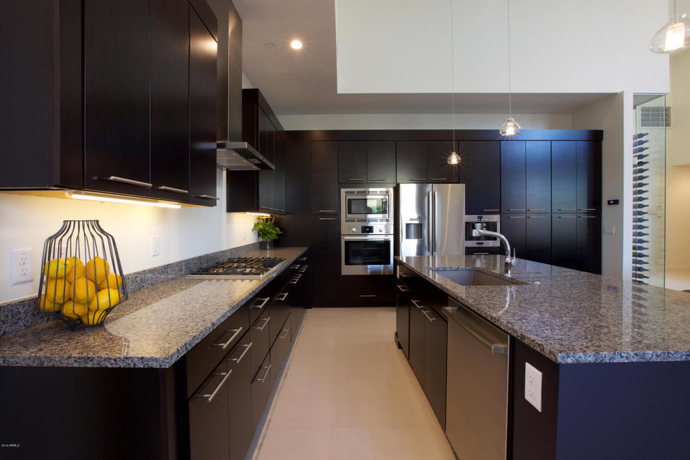 Exempel på ett modernt kök med öppen planlösning, med granitbänkskiva