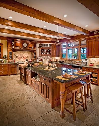 Bild på ett mycket stort rustikt kök, med en undermonterad diskho, luckor med upphöjd panel, skåp i mellenmörkt trä, granitbänkskiva, beige stänkskydd, stänkskydd i stenkakel, rostfria vitvaror, travertin golv och en köksö