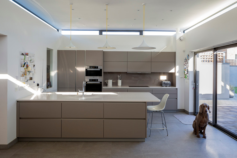 Zweizeilige, Mittelgroße Moderne Wohnküche mit flächenbündigen Schrankfronten, grauen Schränken, Keramikboden und Kücheninsel in London