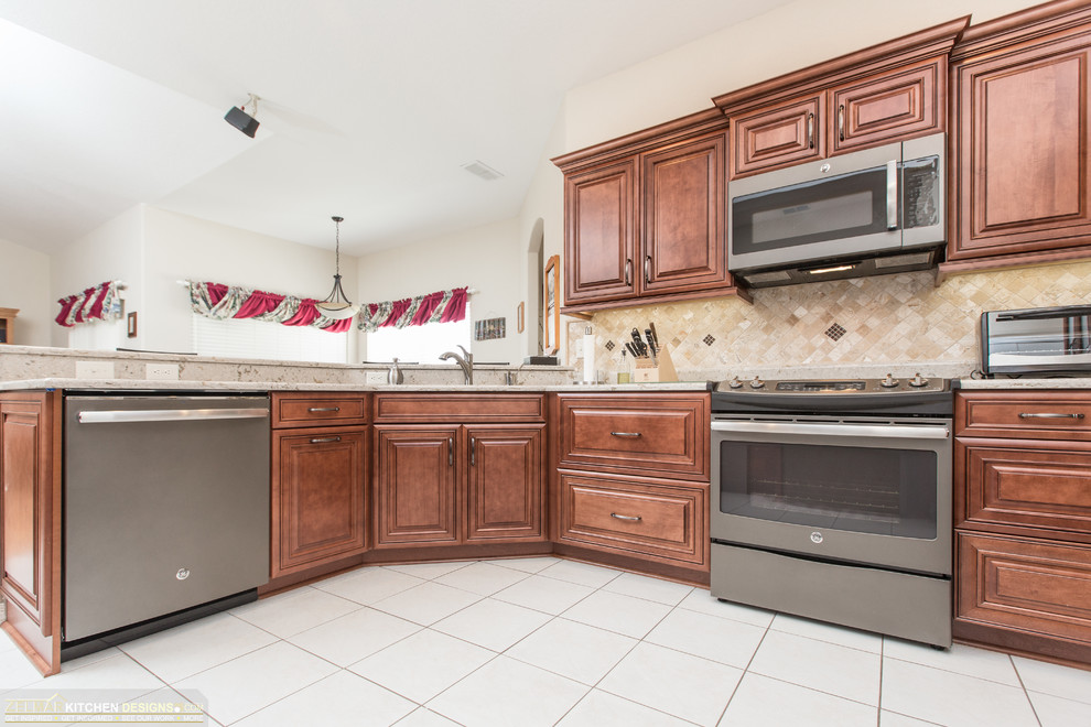 Inspiration for a mid-sized timeless l-shaped kitchen pantry remodel in Orlando with an undermount sink, raised-panel cabinets, medium tone wood cabinets, quartz countertops, multicolored backsplash, travertine backsplash and no island