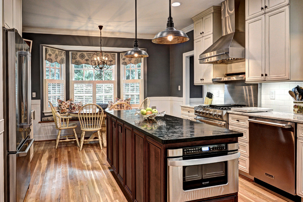 ワシントンD.C.にあるトランジショナルスタイルのおしゃれなダイニングキッチン (インセット扉のキャビネット、ベージュのキャビネット、白いキッチンパネル、サブウェイタイルのキッチンパネル、シルバーの調理設備) の写真