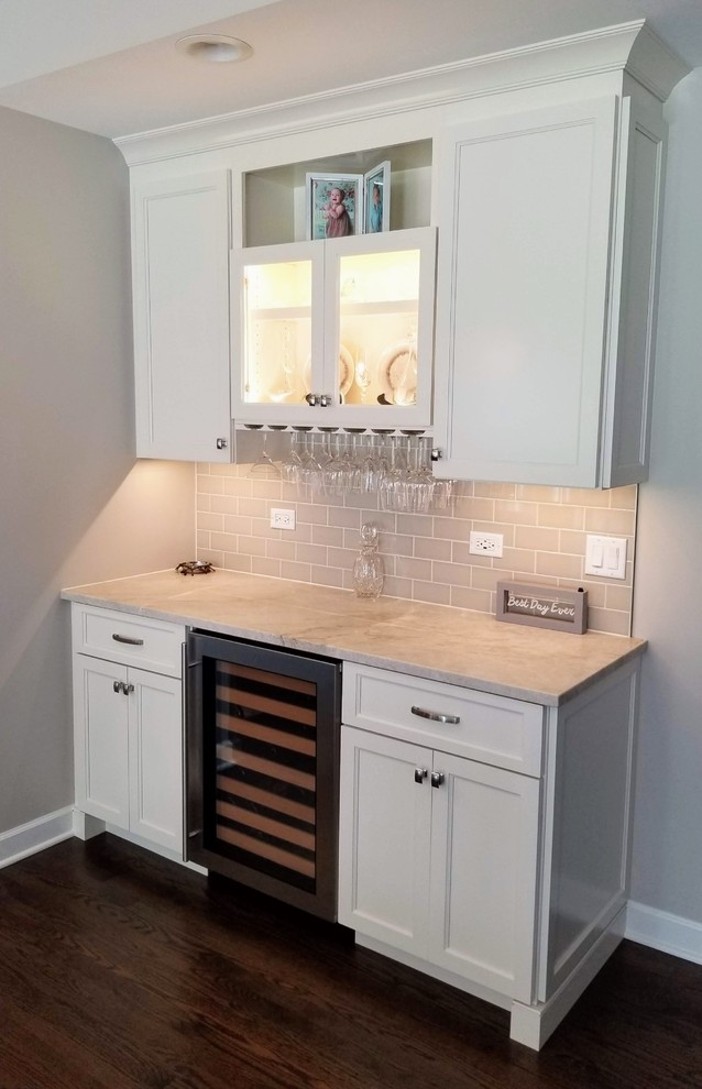 Inspiration for a transitional u-shaped medium tone wood floor kitchen remodel in Chicago with an undermount sink, shaker cabinets, white cabinets, quartzite countertops, porcelain backsplash and stainless steel appliances