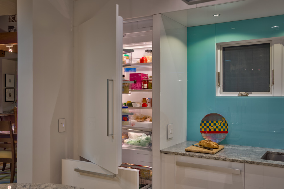Foto di una cucina design di medie dimensioni con lavello sottopiano, ante lisce, ante bianche, top in granito, paraspruzzi blu, elettrodomestici bianchi e parquet chiaro