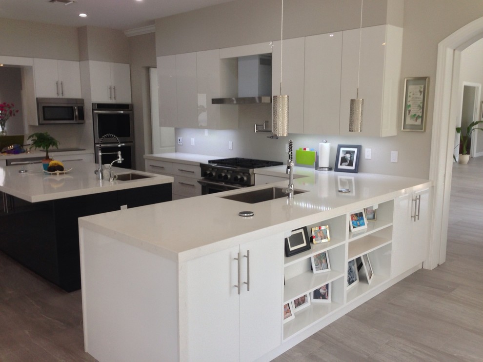 Example of a huge minimalist u-shaped porcelain tile open concept kitchen design in Miami with an undermount sink, flat-panel cabinets, white cabinets, quartz countertops, white backsplash, stainless steel appliances and an island