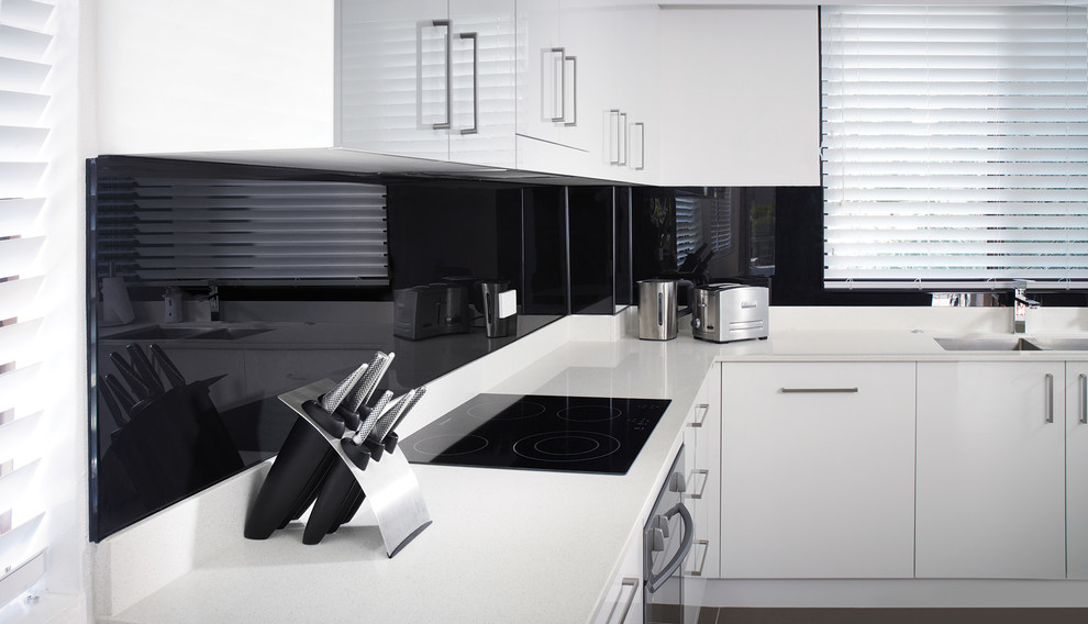 Contemporary kitchen in Columbus with flat-panel cabinets and glass sheet splashback.