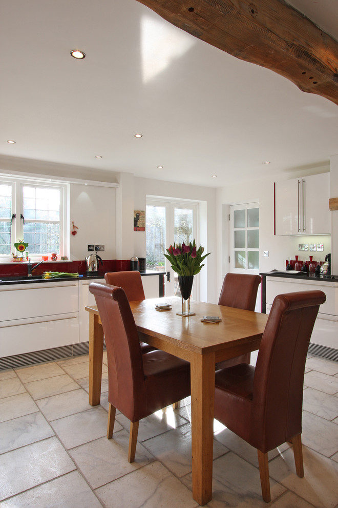 Immagine di una cucina abitabile design con ante lisce e ante bianche