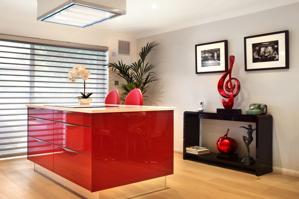 Inspiration for a medium sized contemporary single-wall kitchen/diner in Buckinghamshire with red cabinets, quartz worktops, stainless steel appliances, light hardwood flooring, an island, an integrated sink and flat-panel cabinets.