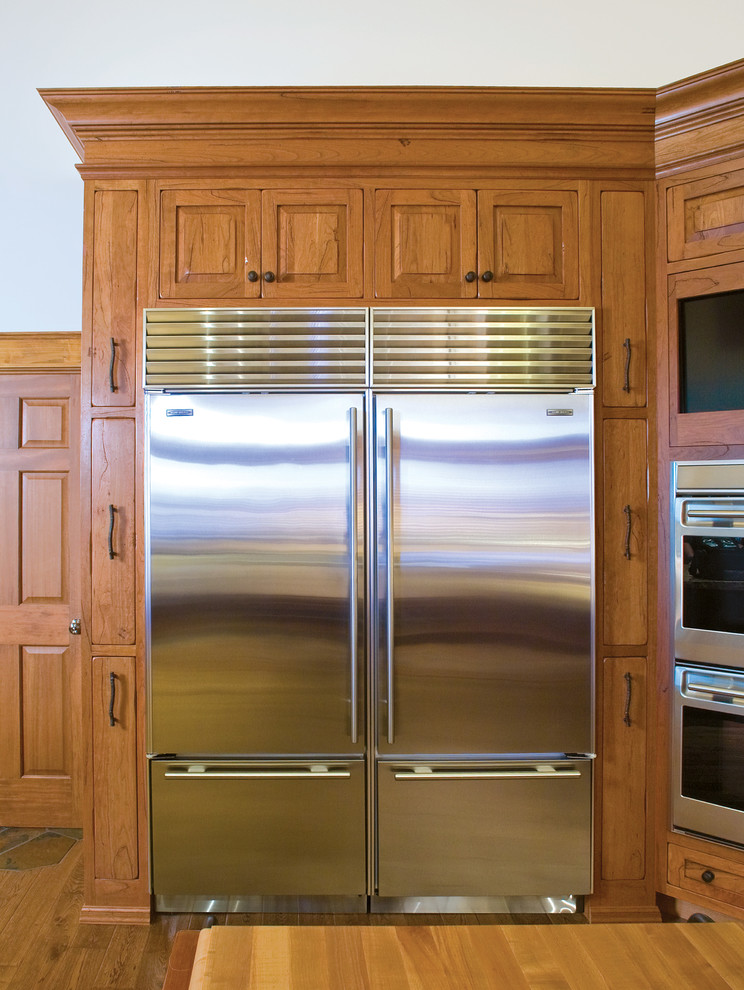 Foto de cocina rústica con puertas de armario de madera oscura y electrodomésticos de acero inoxidable