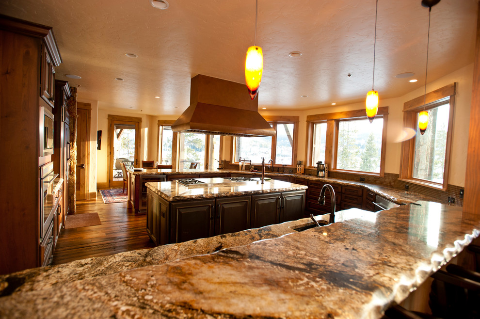 Example of a large transitional u-shaped medium tone wood floor eat-in kitchen design in Denver with an undermount sink, raised-panel cabinets, distressed cabinets, granite countertops, multicolored backsplash and stainless steel appliances