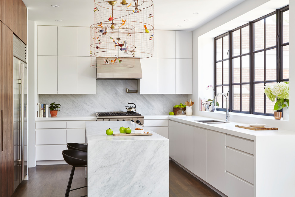 Mid-sized trendy u-shaped medium tone wood floor and brown floor open concept kitchen photo in Toronto with flat-panel cabinets, white cabinets, quartz countertops, gray backsplash, stone slab backsplash, stainless steel appliances, an island and a double-bowl sink