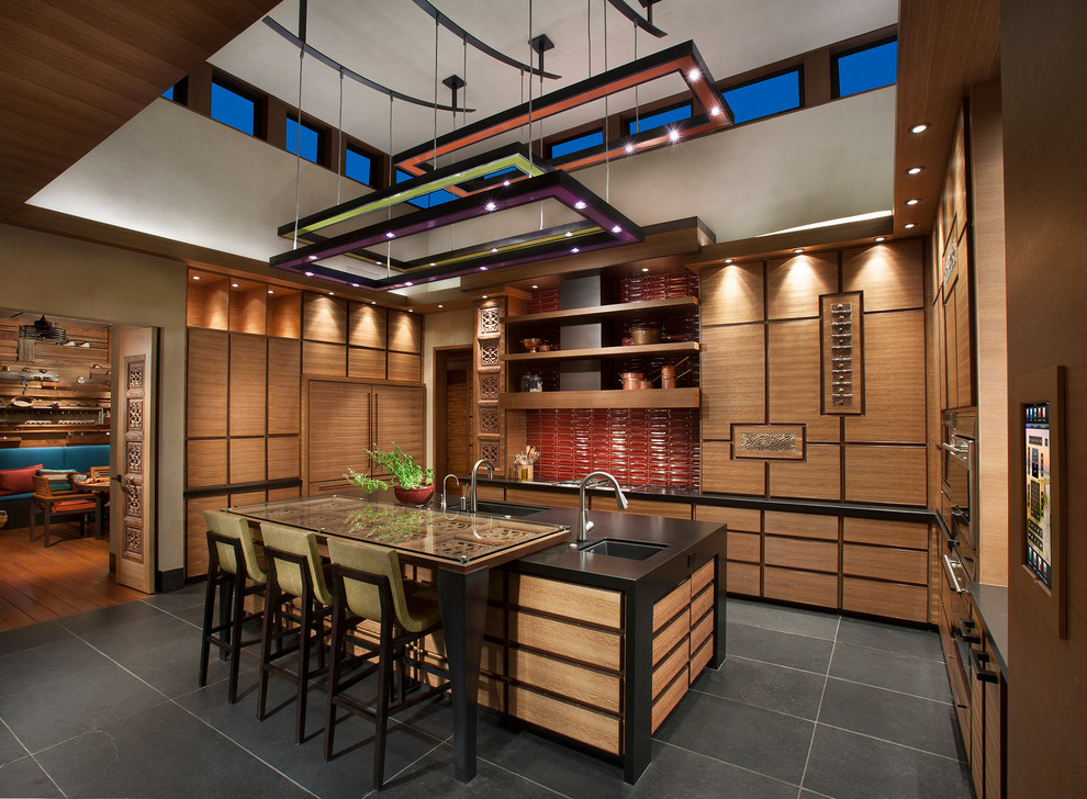 Inspiration for a large southwestern u-shaped slate floor and gray floor eat-in kitchen remodel in Phoenix with flat-panel cabinets, medium tone wood cabinets, onyx countertops, red backsplash, paneled appliances, an undermount sink, ceramic backsplash and an island