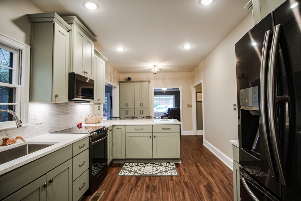 Foto på ett mellanstort funkis grå kök, med en undermonterad diskho, skåp i shakerstil, gröna skåp, bänkskiva i kvartsit, vitt stänkskydd, stänkskydd i keramik, svarta vitvaror, vinylgolv och brunt golv
