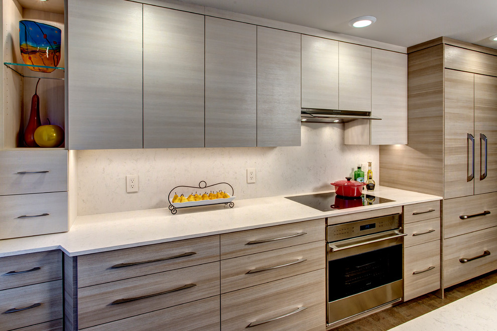 Foto på ett litet funkis kök, med en undermonterad diskho, släta luckor, bruna skåp, bänkskiva i kvarts, beige stänkskydd, rostfria vitvaror, korkgolv och en halv köksö