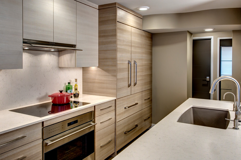 Modern inredning av ett litet kök, med en undermonterad diskho, släta luckor, bruna skåp, bänkskiva i kvarts, beige stänkskydd, rostfria vitvaror och en halv köksö