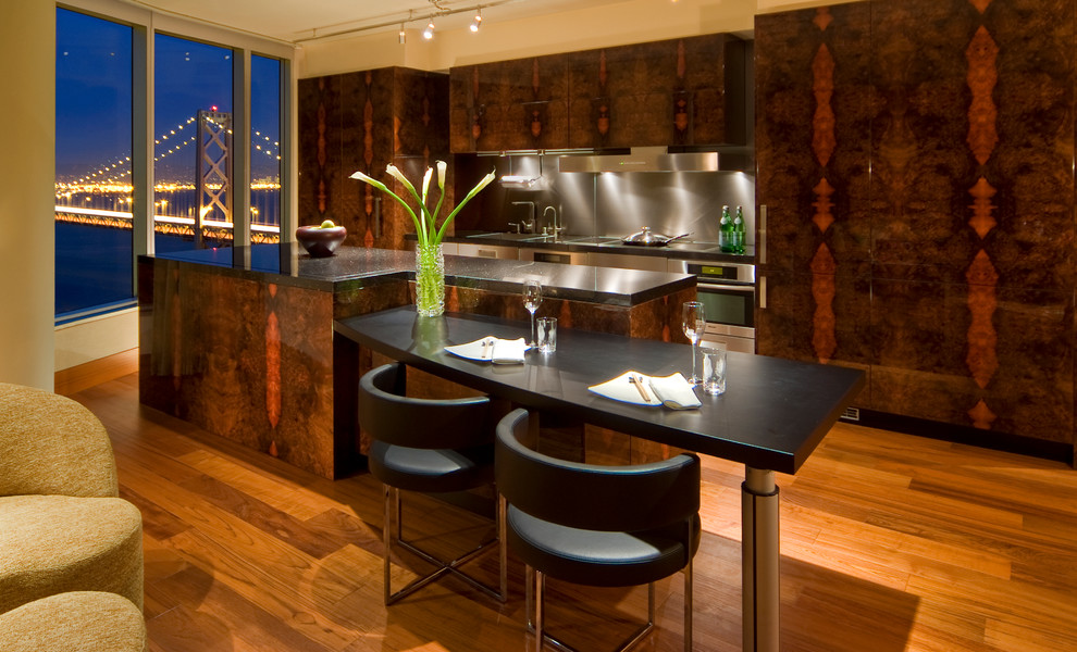 Immagine di una cucina moderna di medie dimensioni con elettrodomestici da incasso, lavello sottopiano, ante lisce, pavimento in legno massello medio, ante in legno bruno, top in acciaio inossidabile e pavimento marrone