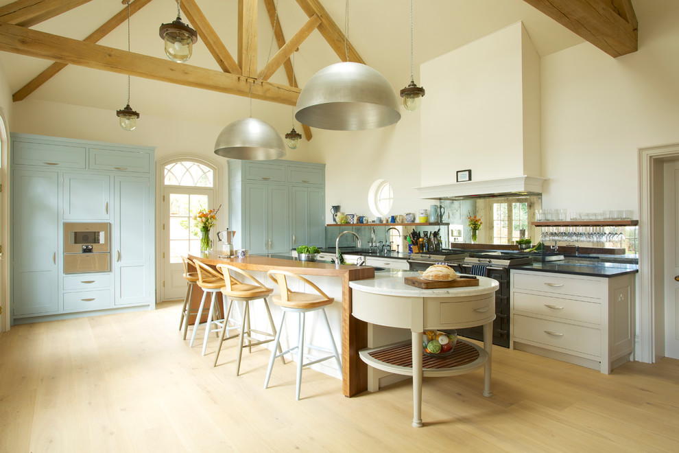 Große Klassische Küche mit Schrankfronten im Shaker-Stil, blauen Schränken, hellem Holzboden und Kücheninsel in Wiltshire