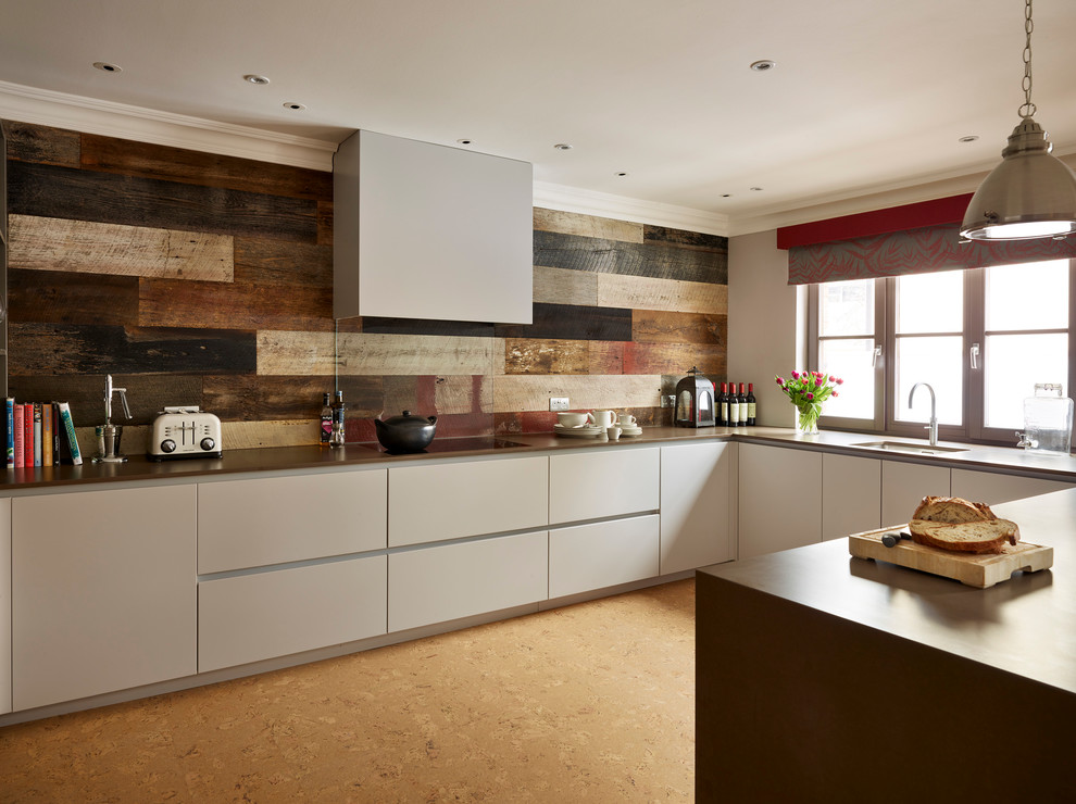 Bild på ett funkis kök och matrum, med släta luckor, grå skåp, bänkskiva i kvartsit, korkgolv och en köksö