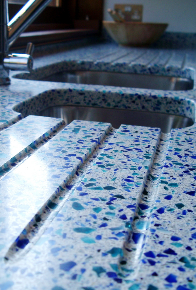 Idéer för ett mellanstort modernt blå l-kök, med bänkskiva i återvunnet glas, blått stänkskydd och en köksö