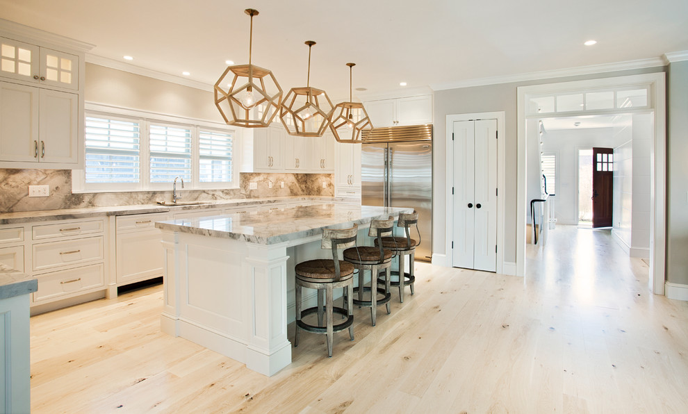 Inspiration for a large transitional u-shaped light wood floor eat-in kitchen remodel in Boston with an undermount sink, recessed-panel cabinets, white cabinets, marble countertops, multicolored backsplash, stone slab backsplash, stainless steel appliances and an island