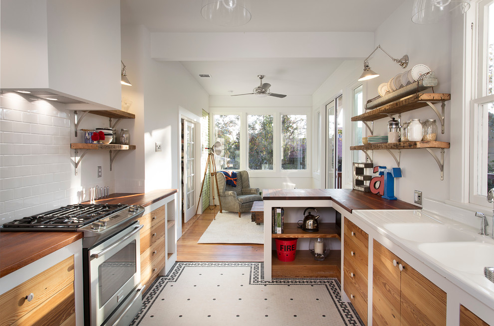 Ejemplo de cocina bohemia cerrada con salpicadero de azulejos tipo metro, encimera de madera, fregadero integrado y armarios abiertos