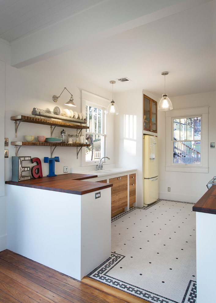 Example of an eclectic kitchen design in Austin with wood countertops