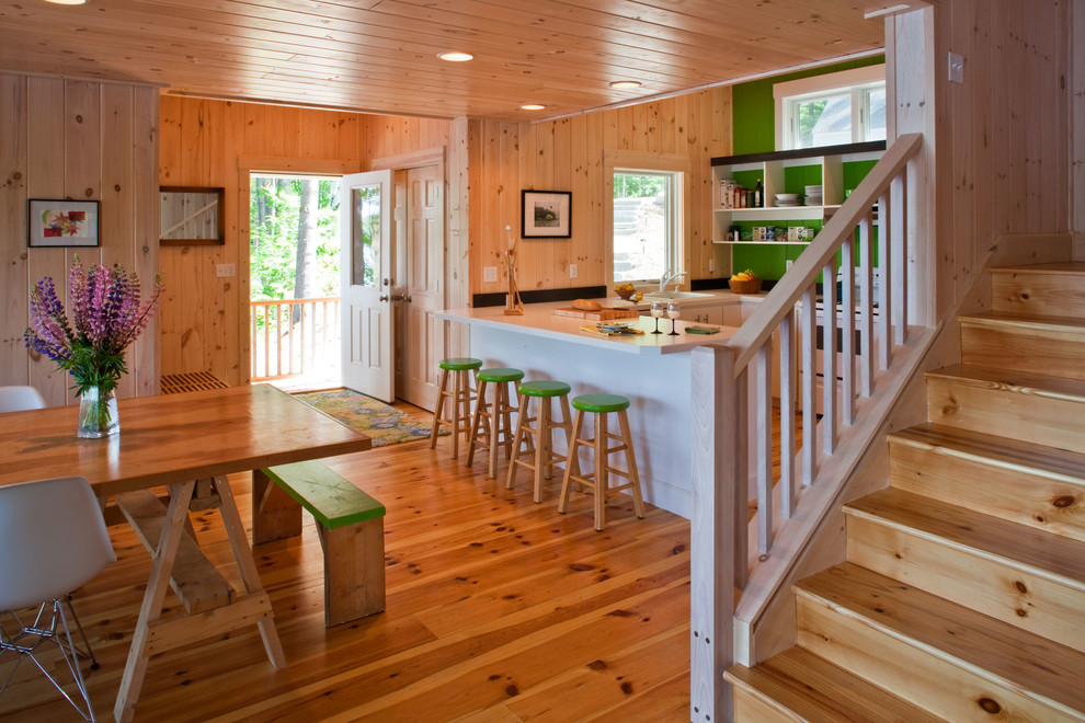 Example of a transitional u-shaped medium tone wood floor open concept kitchen design in Portland Maine with white cabinets, green backsplash and white appliances