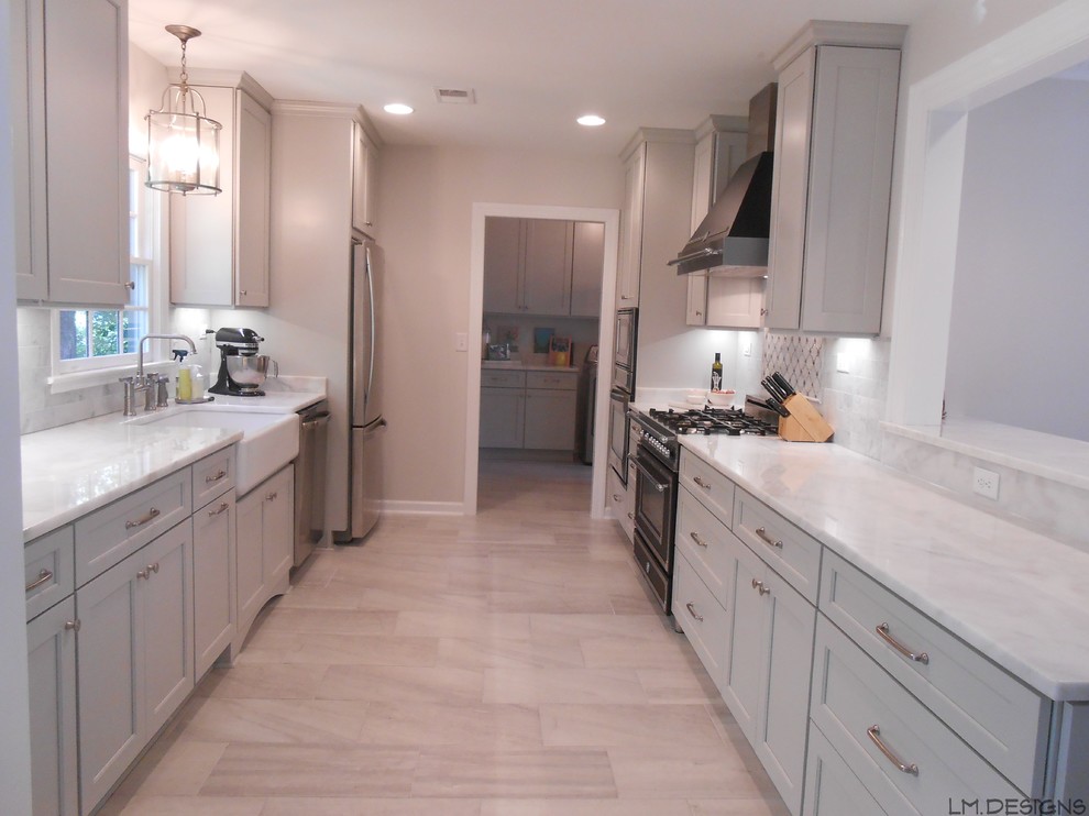 Example of a transitional galley porcelain tile eat-in kitchen design in Other with a farmhouse sink, recessed-panel cabinets, gray cabinets, marble countertops, stone tile backsplash, stainless steel appliances and a peninsula