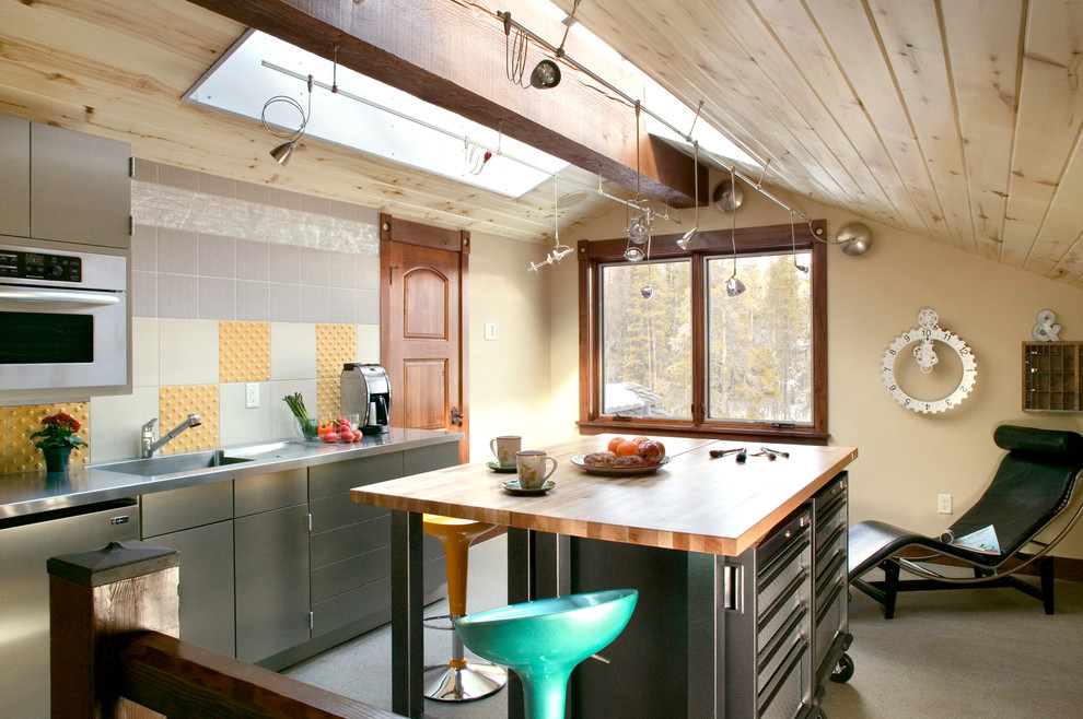 Ejemplo de cocina rústica con armarios con paneles lisos, puertas de armario en acero inoxidable, encimera de madera y salpicadero multicolor