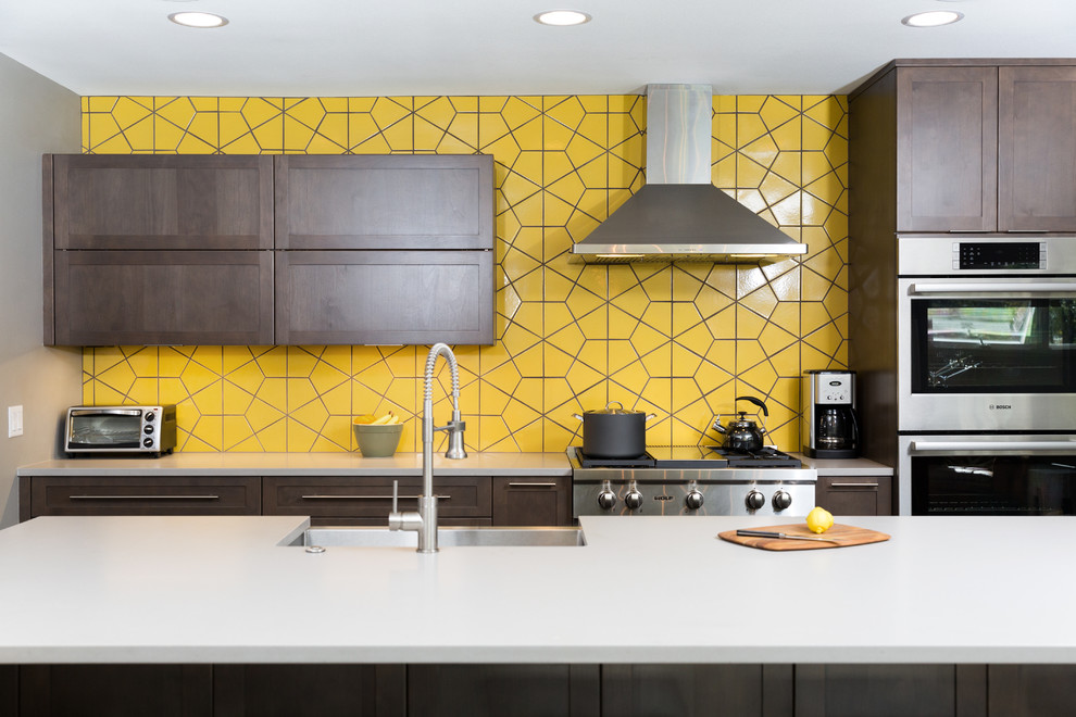 Example of a large trendy single-wall eat-in kitchen design in Dallas with an undermount sink, flat-panel cabinets, dark wood cabinets, quartz countertops, yellow backsplash, ceramic backsplash, stainless steel appliances and an island