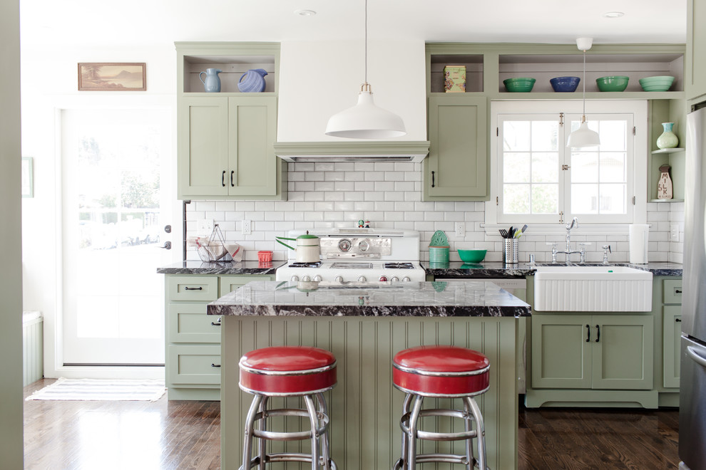 Klassische Küche mit grünen Schränken, Küchenrückwand in Weiß, Rückwand aus Metrofliesen, Kücheninsel und Landhausspüle in Los Angeles
