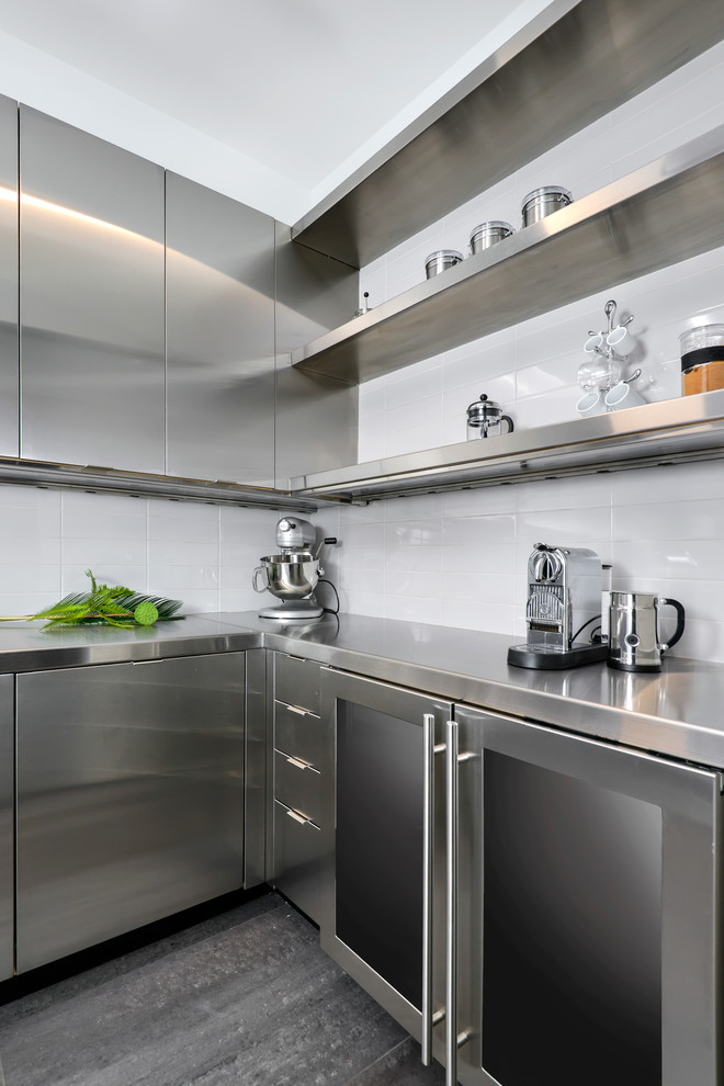 Ejemplo de cocina contemporánea con despensa, puertas de armario en acero inoxidable, encimera de acero inoxidable, salpicadero blanco y electrodomésticos de acero inoxidable