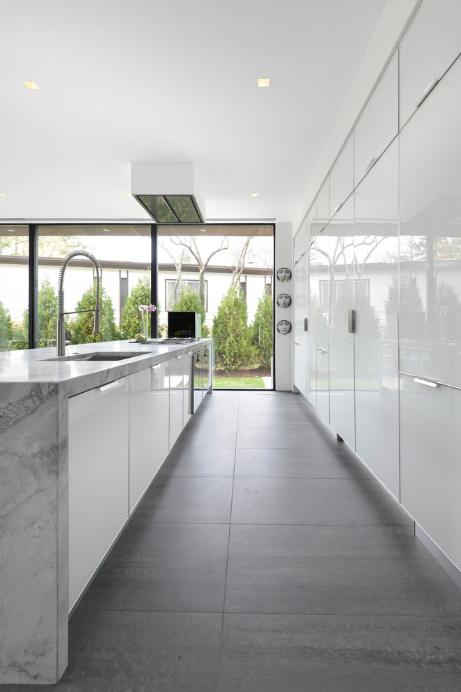 На фото: кухня в современном стиле с белыми фасадами, столешницей из кварцита, полом из керамогранита и серым полом
