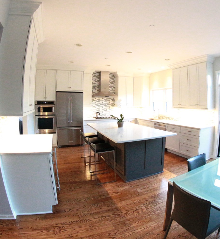 Exempel på ett mellanstort modernt kök, med en undermonterad diskho, skåp i shakerstil, vita skåp, marmorbänkskiva, grått stänkskydd, stänkskydd i stickkakel, rostfria vitvaror, mellanmörkt trägolv och en köksö