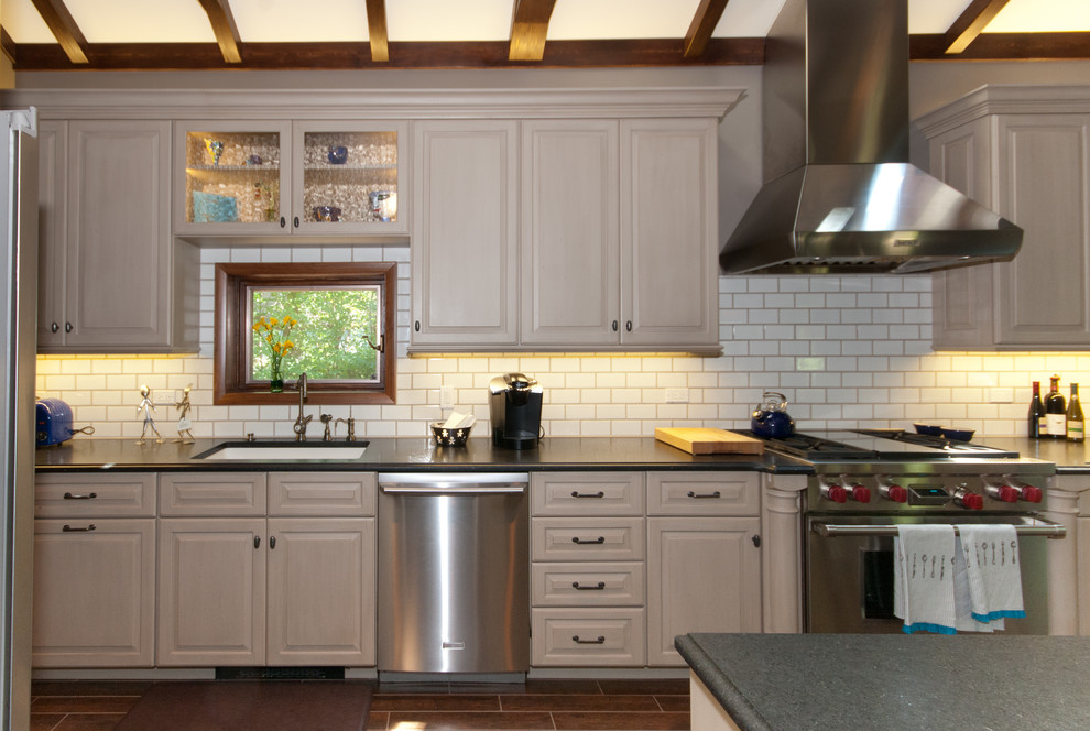 Idéer för att renovera ett mellanstort vintage kök, med en undermonterad diskho, luckor med upphöjd panel, vita skåp, bänkskiva i täljsten, vitt stänkskydd, stänkskydd i tunnelbanekakel, rostfria vitvaror, mörkt trägolv och en köksö