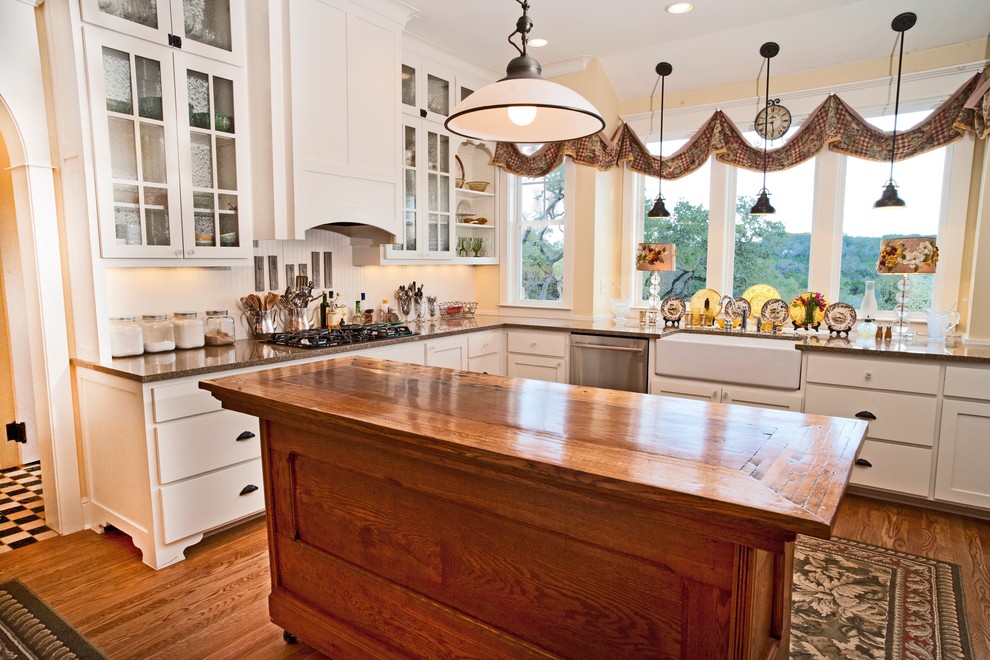 Photo of a classic kitchen in Austin with glass-front cabinets and a belfast sink.
