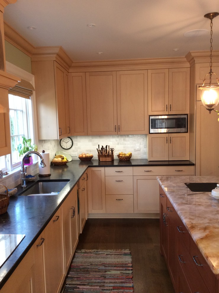 Photo of a medium sized classic l-shaped enclosed kitchen in New York with a submerged sink, recessed-panel cabinets, light wood cabinets, onyx worktops, beige splashback, ceramic splashback, dark hardwood flooring, an island and integrated appliances.