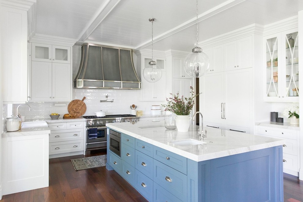 Inspiration for a large timeless l-shaped dark wood floor kitchen remodel in Salt Lake City with a farmhouse sink, shaker cabinets, blue cabinets, white backsplash, subway tile backsplash, stainless steel appliances, an island and white countertops