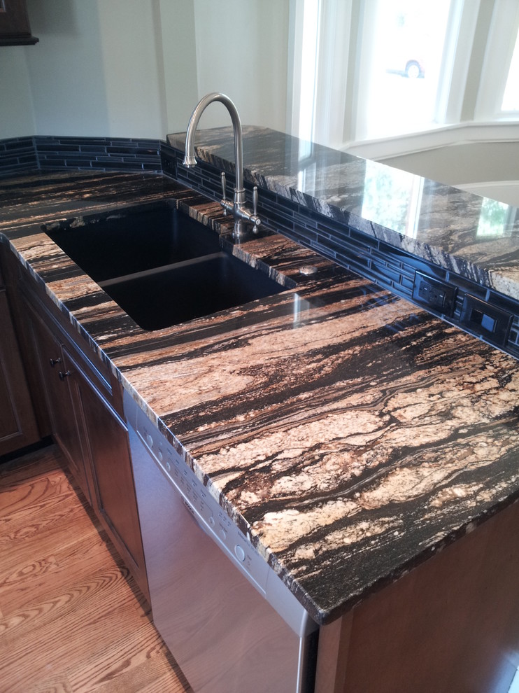 Example of a mid-sized classic u-shaped medium tone wood floor kitchen design in Denver with an undermount sink, shaker cabinets, brown cabinets, granite countertops and stainless steel appliances