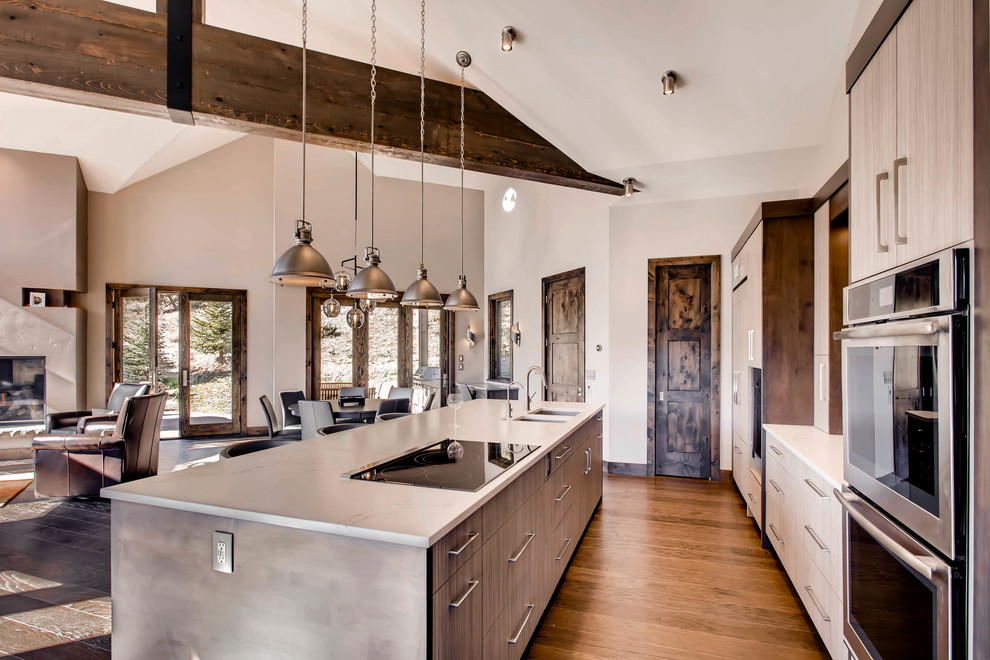 Inspiration for a large modern single-wall dark wood floor and brown floor open concept kitchen remodel in Denver with an undermount sink, flat-panel cabinets, gray cabinets, marble countertops, brown backsplash, slate backsplash, stainless steel appliances and an island
