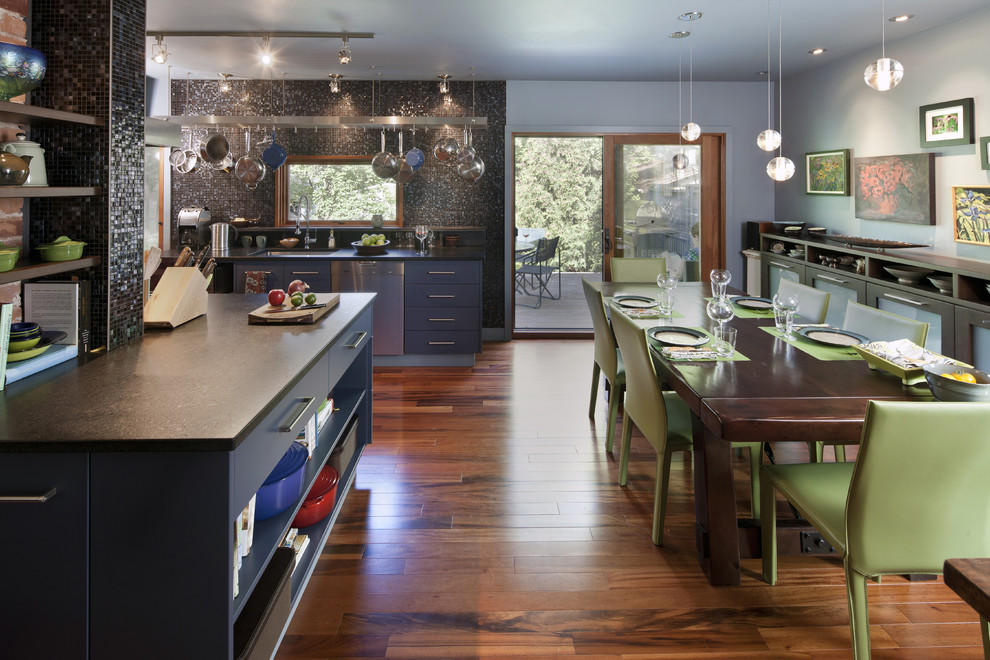 Idéer för ett eklektiskt kök och matrum, med rostfria vitvaror, granitbänkskiva, släta luckor, blå skåp, svart stänkskydd och stänkskydd i mosaik