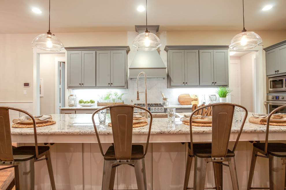 Inspiration for a large transitional l-shaped medium tone wood floor open concept kitchen remodel in Dallas with an undermount sink, shaker cabinets, blue cabinets, granite countertops, white backsplash, subway tile backsplash, stainless steel appliances and an island