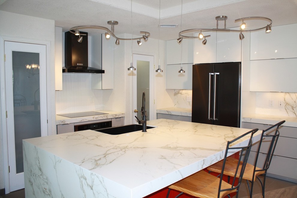 Example of a small trendy l-shaped ceramic tile eat-in kitchen design in Denver with a farmhouse sink, flat-panel cabinets, white cabinets, marble countertops, marble backsplash, black appliances and an island
